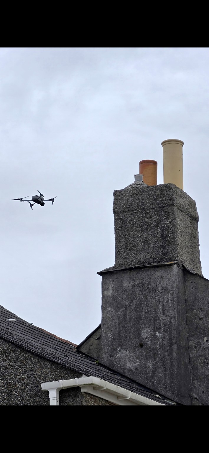 AKM drone positioned beside a chimney stack