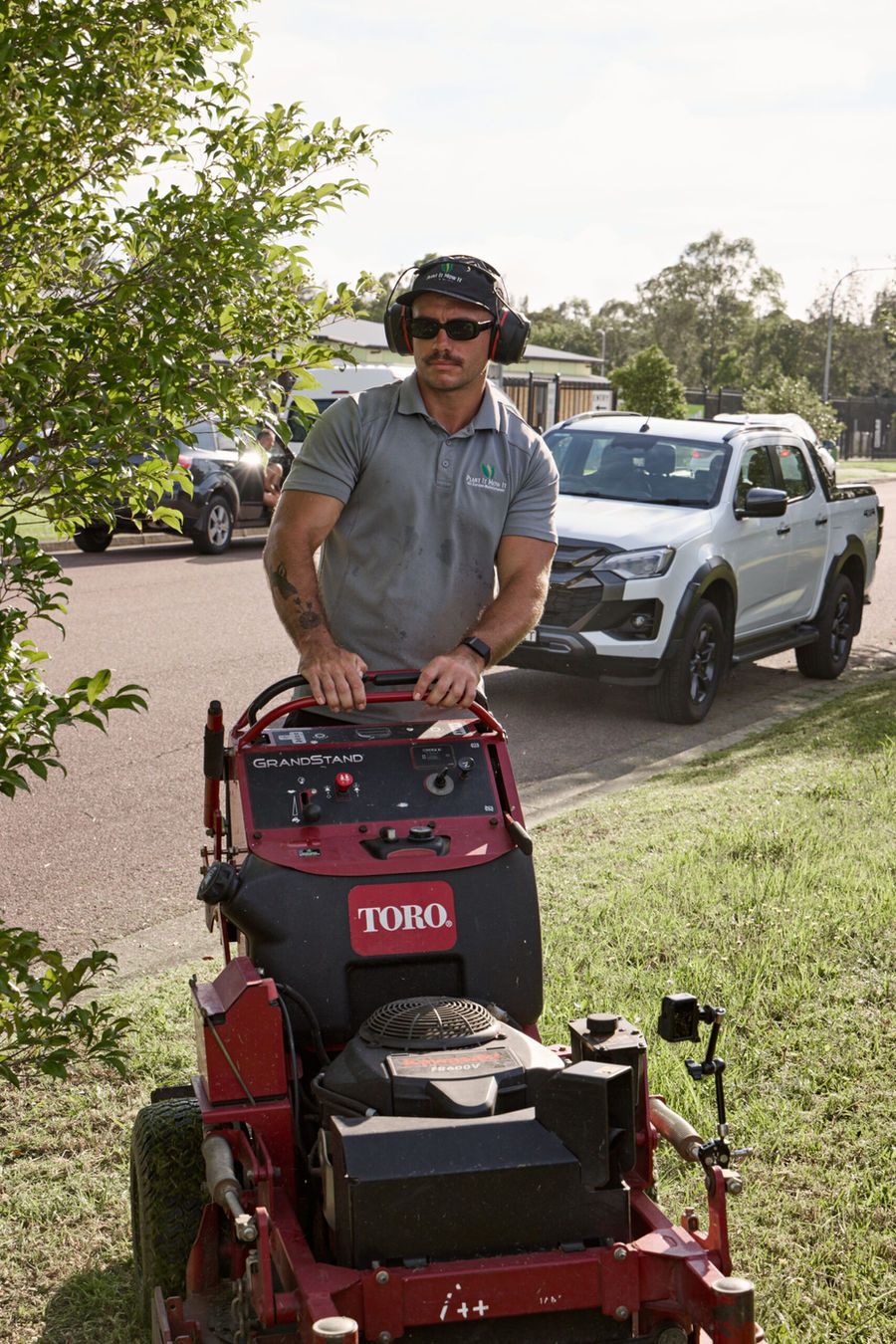 SPROUt team member mowing a nature strip with a stand-on mower