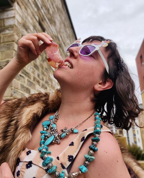 Adrienne, Founder of Crown & Queue, eating cured meat