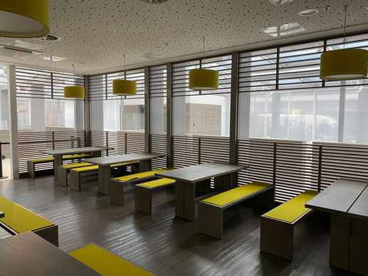 Bild von weiteren Sitzbereichen mit Tischen und Sitzbänken und gelben Auflagen