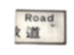 Book cover with half of the title 'Nathan Road' in the format of a white street sign with black lettering.