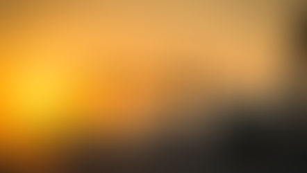 Airplanes line up on a runway at sunrise, silhouetted against a vibrant orange sky. The scene conveys a calm, serene mood.