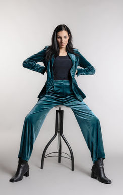 Fashionfoto eines dunkelhaarigen Models in einem schicken grünen Anzug.