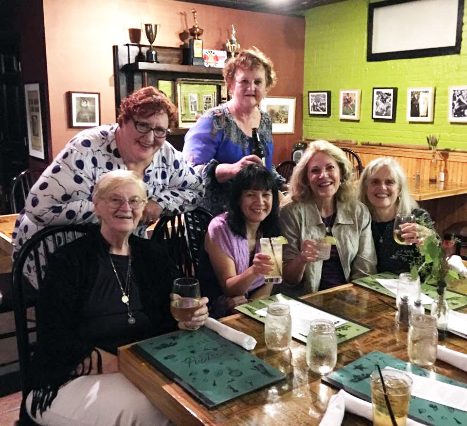 women in a bar with drinks in their hands