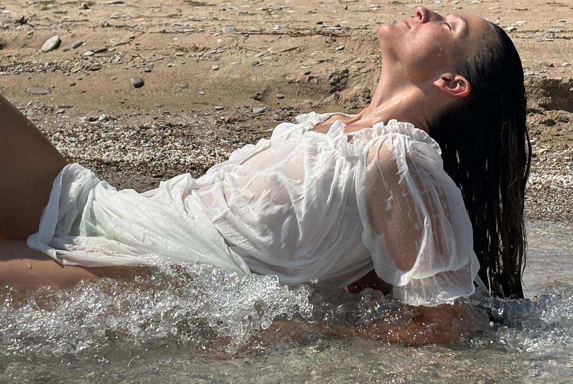 Woman on a beach during intimate portrait photography session celebrating self-expression