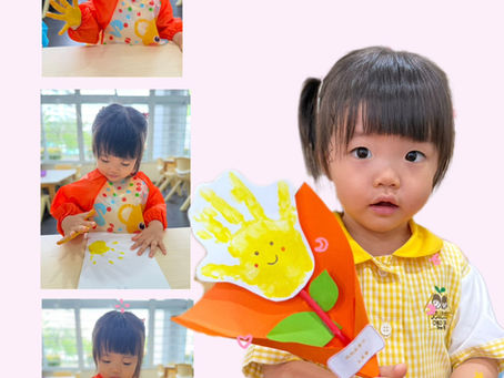 A child making a cheerful handprint flower for Motherâs Day.