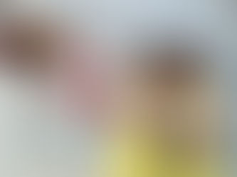 Two girls hold blossom branches beside New Year decorations.