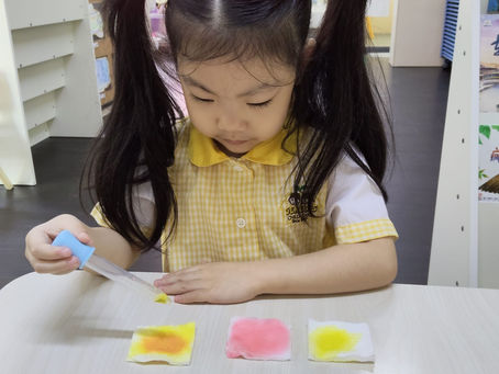 A kid putting different colors on a tissue paper