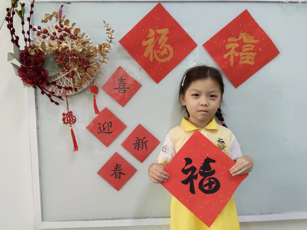 A child holding a red “Fu” decoration for Lunar New Year.