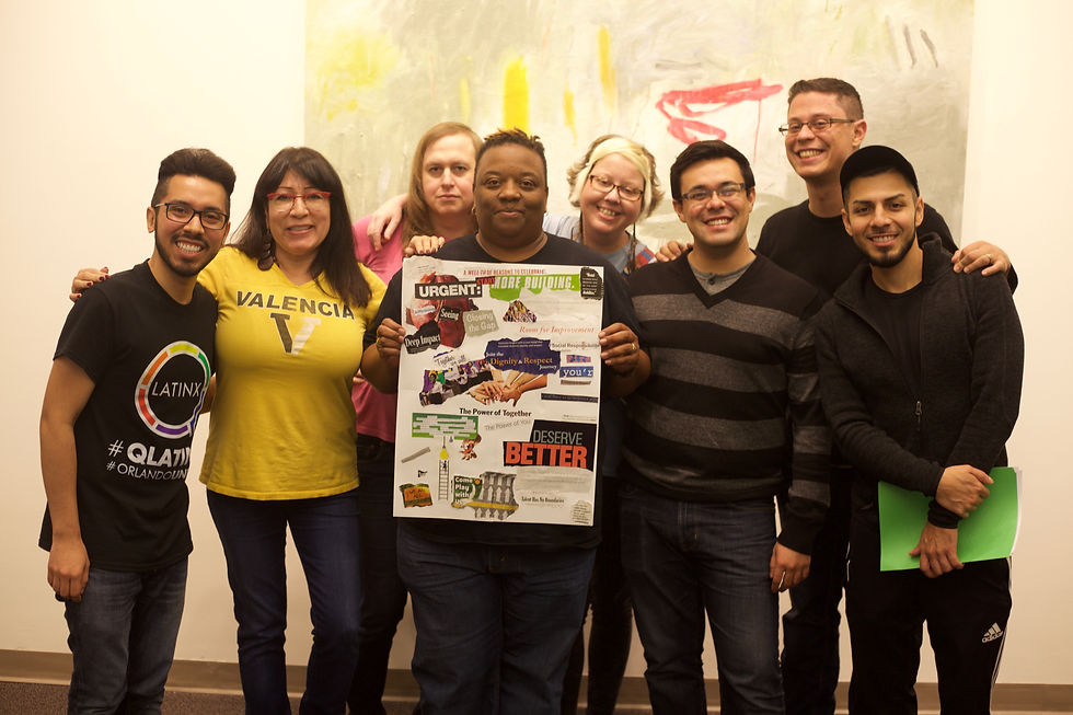 Members of QLatinx, and community organizers from the local community, smiling and holding up a vision board following a workshop that explored state violence.
