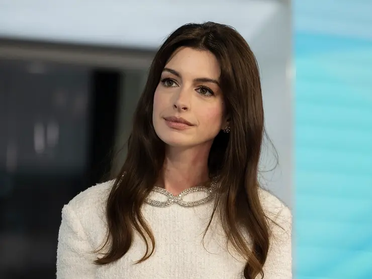 Anne Hathaway, white dress, brown hair, natural makeup, brown eyes, blue background, silver earrings, silver necklace