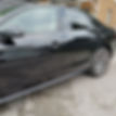 Side view of a shiny sedan parked on a gravel surface