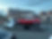 Classic red Jaguar E-Type coupe on a white flatbed recovery lorry at dusk