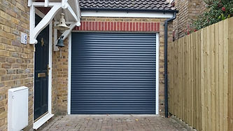 A brick garage with a closed dark blue roll-up door