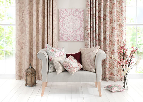 Light grey upholstered chair with floral-patterned cushions