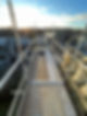Elevated scaffolding platform overlooking rooftops at sunset