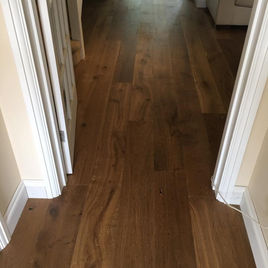 Hallway with warm wooden flooring and white skirting boards