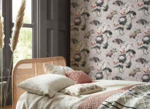 Cozy bedroom with floral wallpaper, rattan bed, and soft pillows