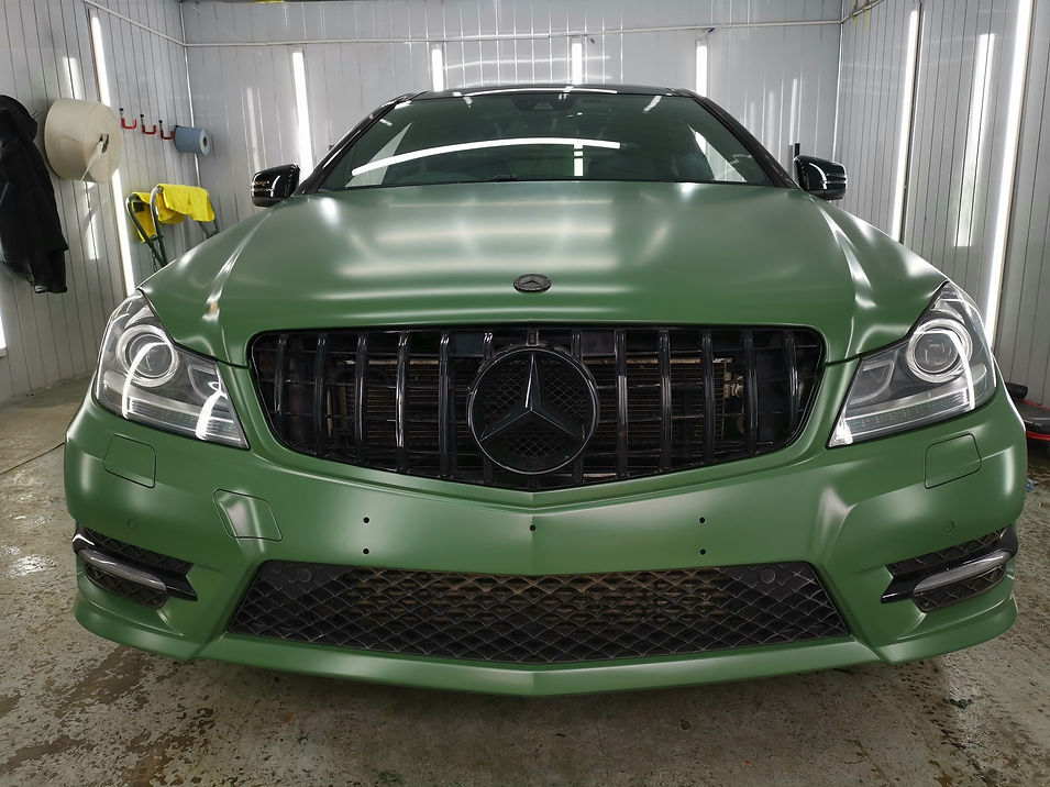 A Mercedes-Benz car viewed from the front in a well-lit garage