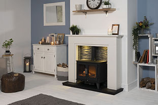 Cast-iron arched insert fireplace with white mantel against a sage green wall