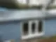 A newly fitted dark grey flat roof on a blue-grey timber garden room or outbuilding