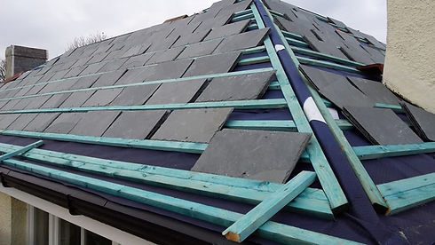 A roof being re-tiled with new slates, showing the battens and membrane