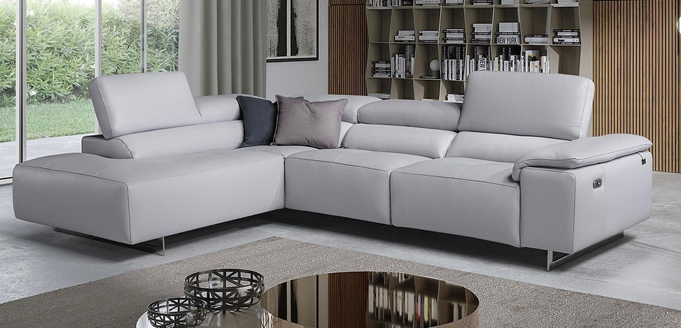 Light grey sectional sofa with cushions in a modern living room with shelving and large windows