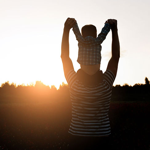 family-therapy. Dad carrying son on his neck in sunlight