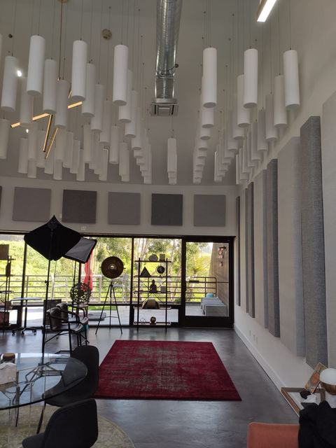 Open space with acoustic treatment including wall panels and ceiling cloud
