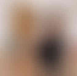 Mum breastfeeding her child whilst exercising with other Mums exercising in the background