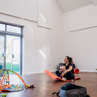 Mum sitting on an exercise mat feeding her child