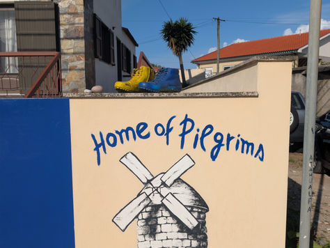 Pilgrim boots beside Camino de Santiago trail marker in Spain