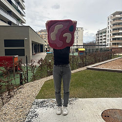 A participent holding a tufted rug that is a abstract image