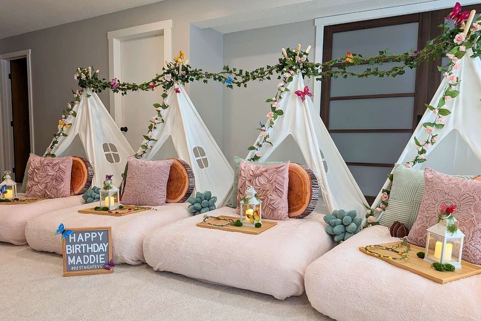 Four decorated white tents on plush beds with lanterns and pillows; sign reads Happy Birthday in a cozy party room.
