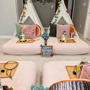Elegant kids sleepover scene with white teepees, green accents, and fairy lights creating a magical woodland feel
