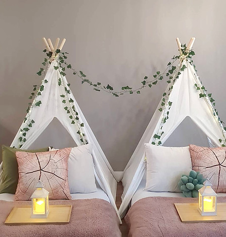 Dream Away Soirée Enchanted Forest sleepover setup with woodland-themed decorations, greenery, and a cozy white linen tent