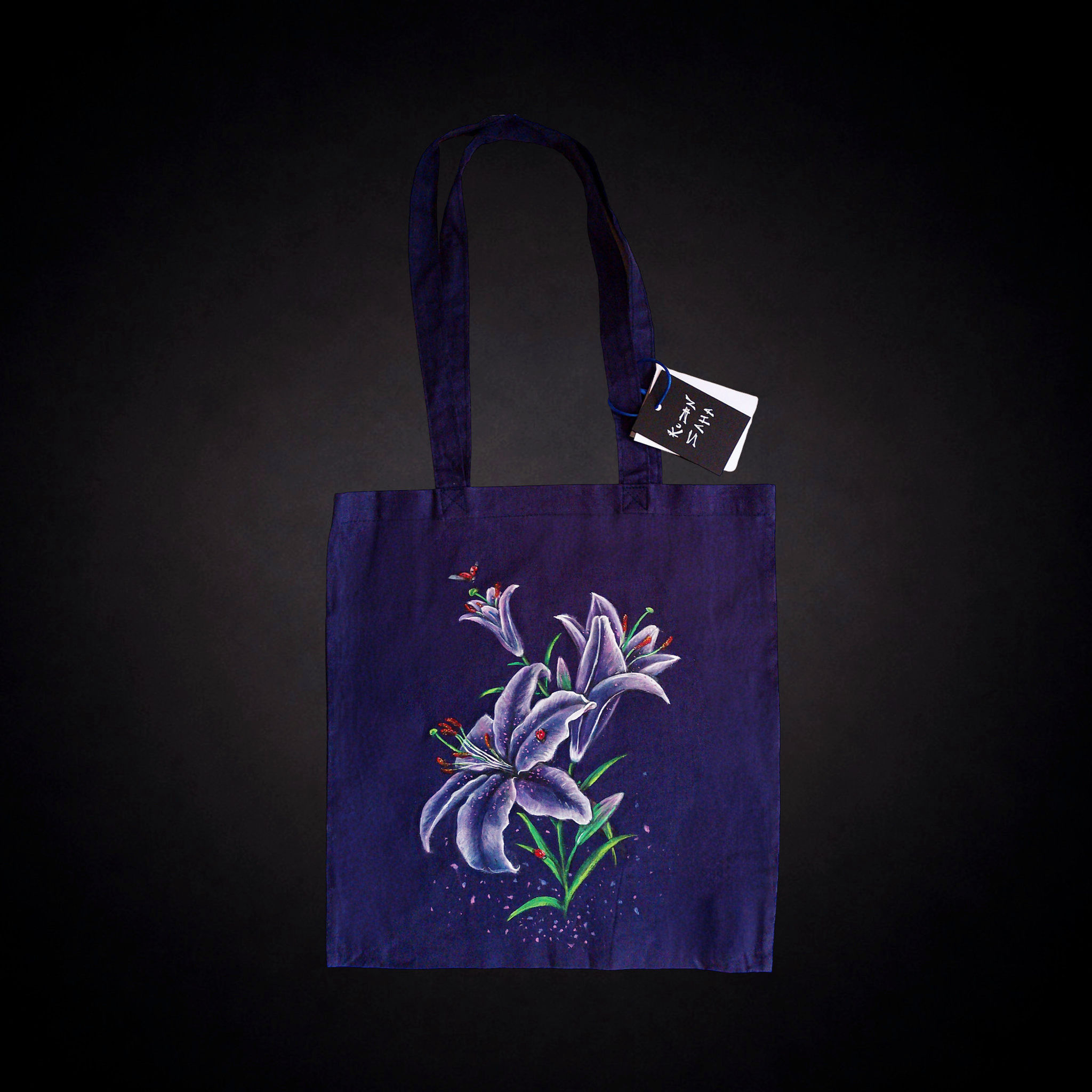 Lirios Nocturnos, tote bag azul violáceo única pintada a mano por Kuzen Saha con lirios y mariquitas.