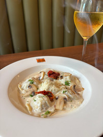 Ravioli Bosco Affumicati - Handmade ravioli filled with smoked chicken, ricotta cheese, and mushrooms, served in a velvety truffle cream sauce
