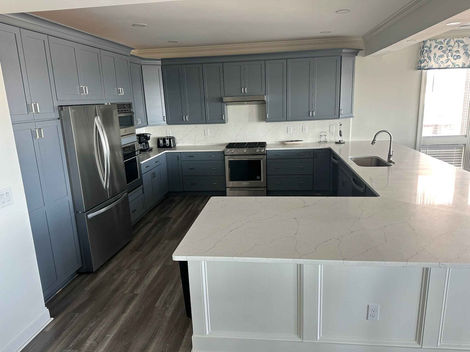 New kitchen remodel with blue cabinets, stainless steel appliances, and white countertops.