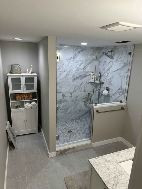 Completed Bathroom install with glass shower door and panel.