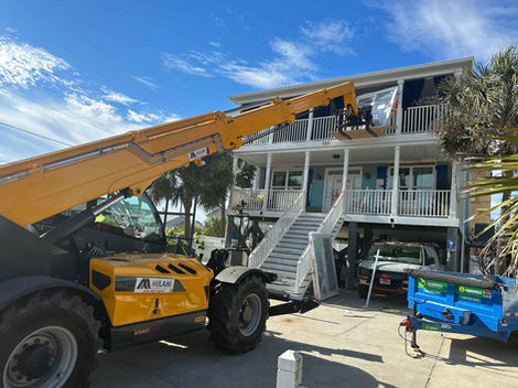 Fork Lift, Lifting Storm Doors onto the second floor of the home for installation.