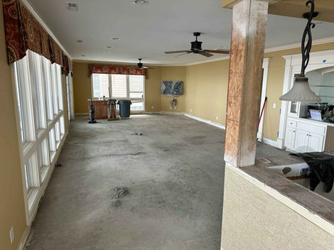 Living room before remodeling, no flooring, dark mustard walls.