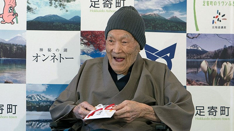 japanischer alter Mann mit Mütze und braunem Mantel,