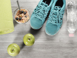 Running shoes, water bottle, and healthy breakfast bowl with apples for summer weight loss
