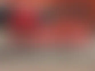 Sofá vermelho gigante diante da loja Etna, com banner promocional: 17 anos, móveis e decoração, 12x sem juros.