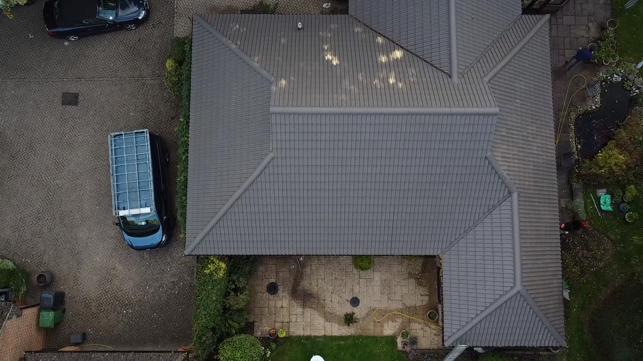 A two-storey red brick house with a neatly maintained garden and a single-car garage.