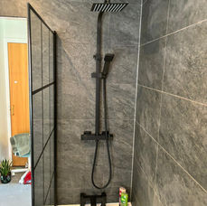 Large warm tiles with a black shower
