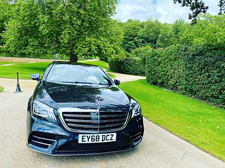 Polished black car in front on green grass