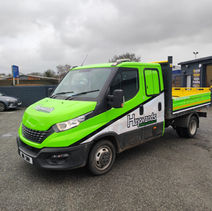 Bright lime green medium sized truck parked with other cars