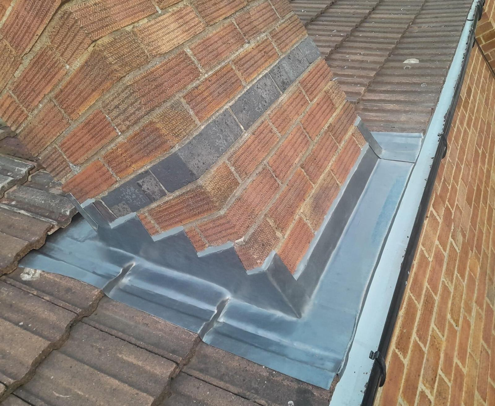 Brick chimney base lead flashing close view.